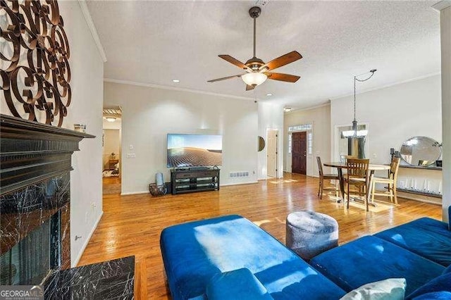 230 Oakmere Dr, Alpharetta, GA 30009 - living room featuring crown molding, ceiling fan, a fireplace, a textured ceiling, and wood finished floors