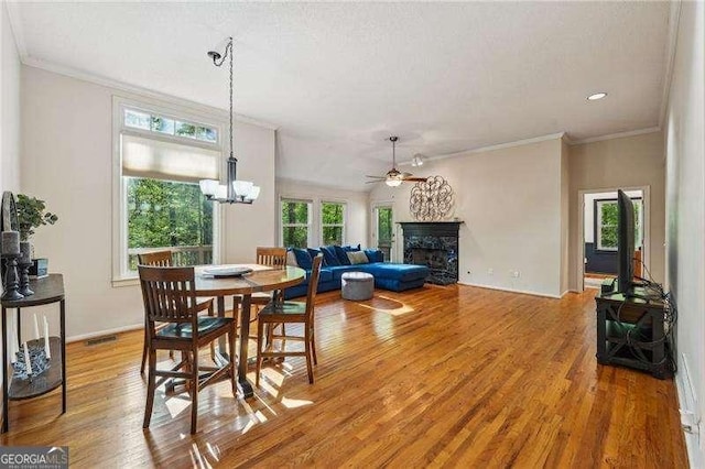 230 Oakmere Dr, Alpharetta, GA 30009 - dining room featuring crown molding, light wood-style flooring, a fireplace, and ceiling fan with notable chandelier