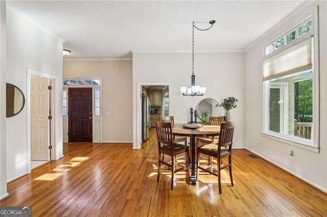 230 Oakmere Dr, Alpharetta, GA 30009 - dining room with ornamental molding, a chandelier, light wood-style flooring, a textured ceiling, and visible vents