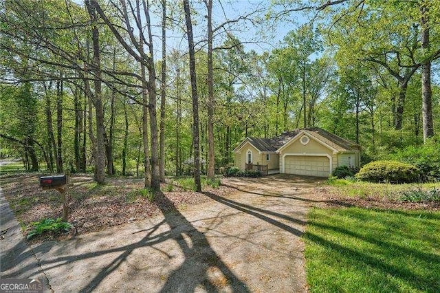 230 Oakmere Dr, Alpharetta, GA 30009 - view of front facade featuring a garage, a forest view, and dirt driveway