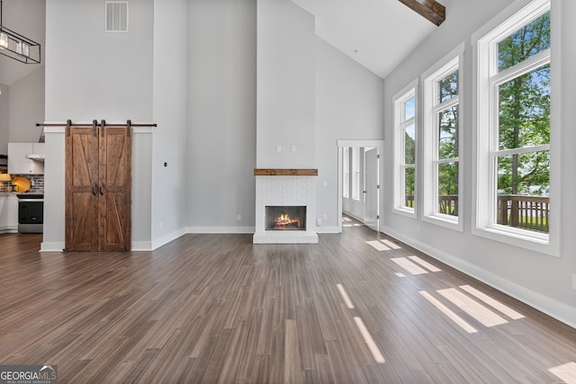 1001 Sugar Hill Way, Buckhead, GA 30625 - unfurnished living room with visible vents, dark wood finished floors, a fireplace, and high vaulted ceiling