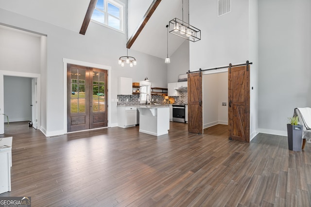 1001 Sugar Hill Way, Buckhead, GA 30625 - unfurnished living room featuring high vaulted ceiling, plenty of natural light, a barn door, and visible vents