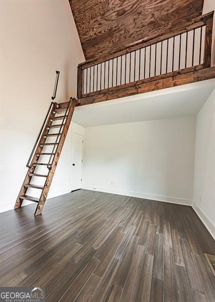 1001 Sugar Hill Way, Buckhead, GA 30625 - unfurnished living room with stairs, dark wood-style flooring, a high ceiling, and baseboards