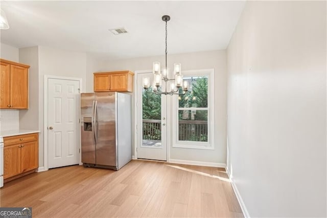 interior space with a notable chandelier, visible vents, baseboards, and light wood-style flooring