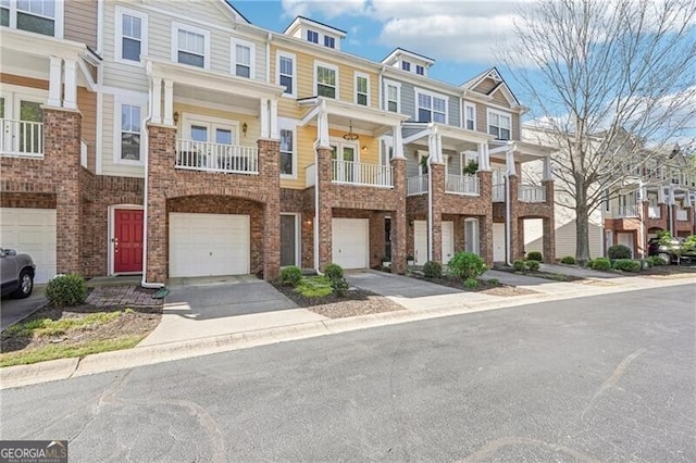 multi unit property with a residential view, driveway, and an attached garage