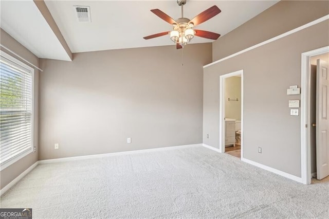 empty room featuring light carpet, ceiling fan, lofted ceiling, and visible vents