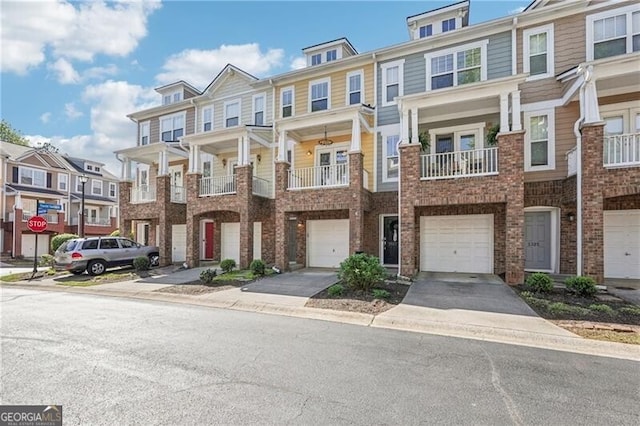 multi unit property featuring a residential view, driveway, and an attached garage