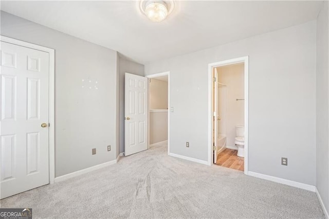 unfurnished bedroom featuring carpet, baseboards, and connected bathroom