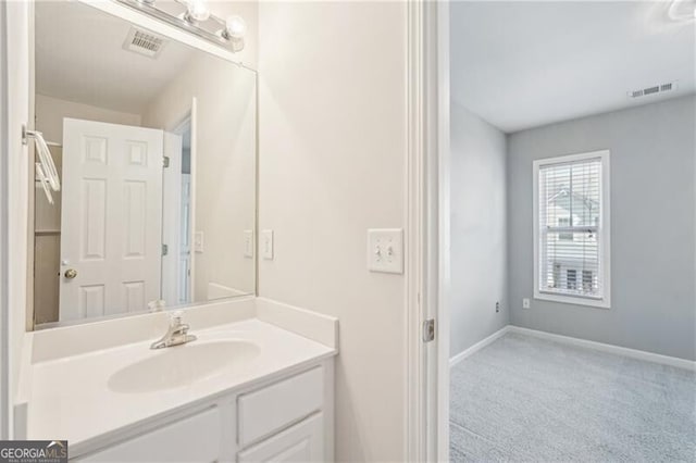bathroom with vanity, visible vents, and baseboards