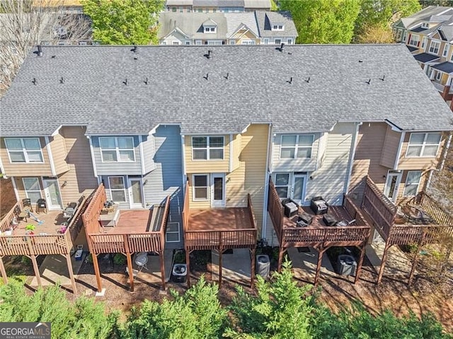 rear view of house with roof with shingles