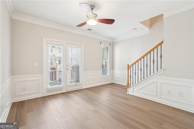 unfurnished living room with a healthy amount of sunlight, wood finished floors, and a decorative wall