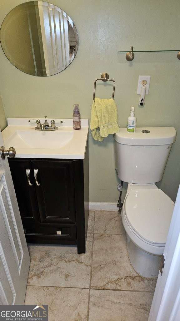 bathroom featuring tile patterned floors, toilet, vanity, and baseboards