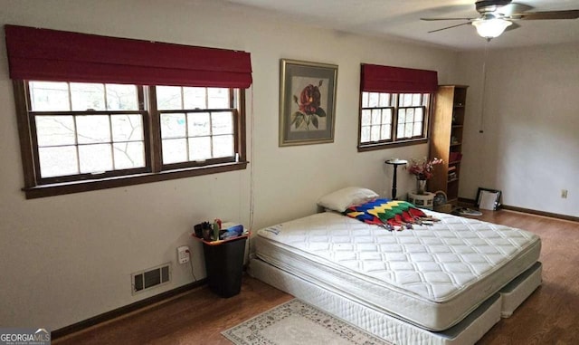 bedroom with visible vents, baseboards, a ceiling fan, and wood finished floors