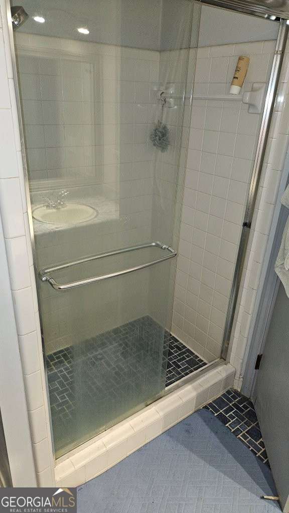 bathroom featuring a sink, tile patterned floors, and a shower stall