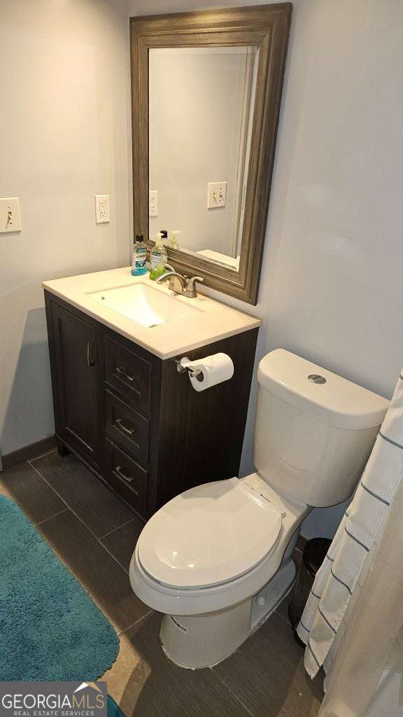 bathroom with tile patterned flooring, toilet, and vanity
