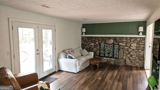 living area with visible vents, french doors, wood finished floors, and a textured ceiling