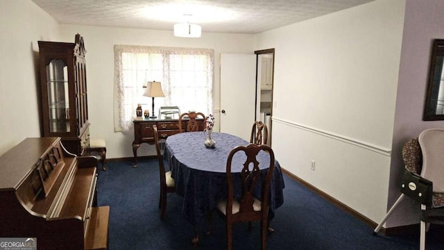 dining space with carpet, baseboards, and a textured ceiling