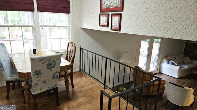 dining area with a wealth of natural light, french doors, wallpapered walls, and wood finished floors