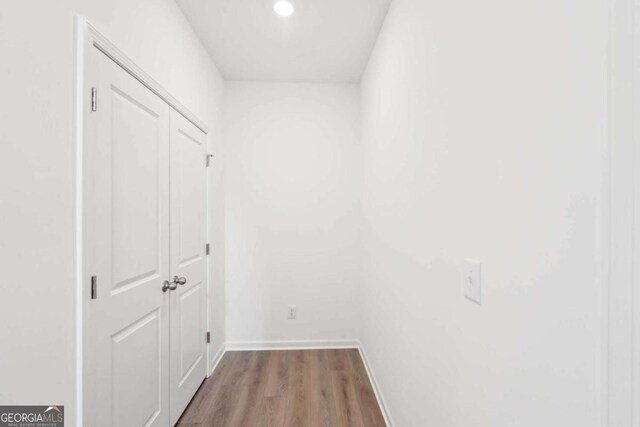 corridor featuring light wood-type flooring, baseboards, and recessed lighting