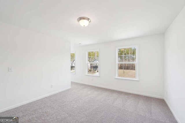 carpeted empty room with baseboards