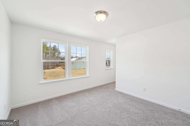 unfurnished room with carpet flooring and baseboards
