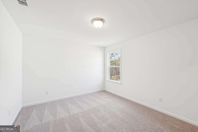 empty room with visible vents, baseboards, and carpet flooring