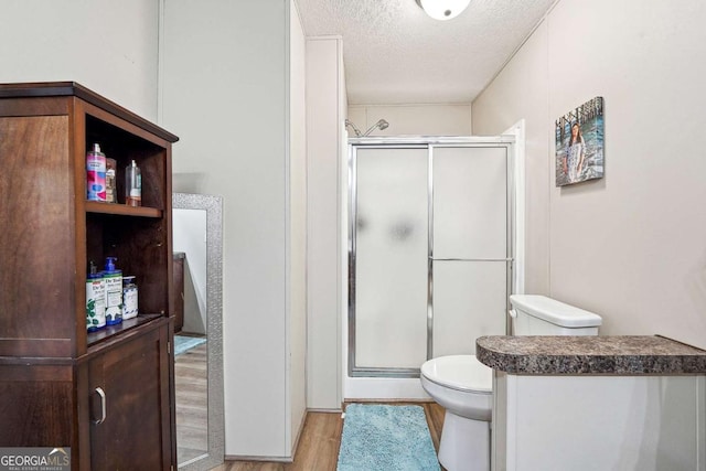 2496 Venture Dr, Gainesville, GA 30506 - full bathroom featuring a shower stall, a textured ceiling, toilet, and wood finished floors