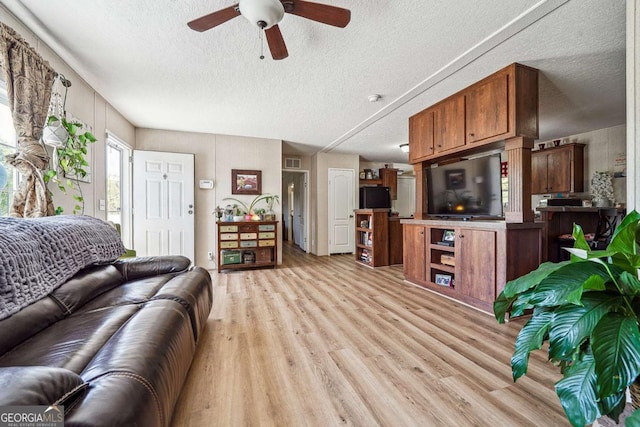 2496 Venture Dr, Gainesville, GA 30506 - living area featuring light wood finished floors, visible vents, a textured ceiling, and a ceiling fan