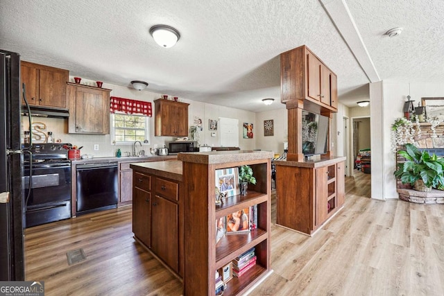 2496 Venture Dr, Gainesville, GA 30506 - kitchen featuring light wood-style floors, open shelves, black appliances, a kitchen island, and under cabinet range hood
