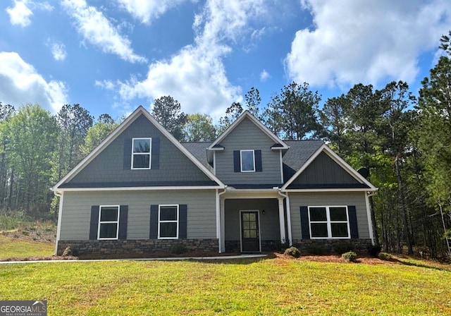 craftsman-style house featuring a front yard and stone siding