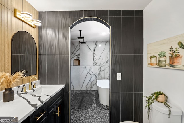 full bath featuring a walk in shower, vanity, toilet, tile walls, and a freestanding bath