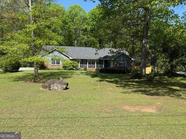 ranch-style home featuring a porch and a front lawn