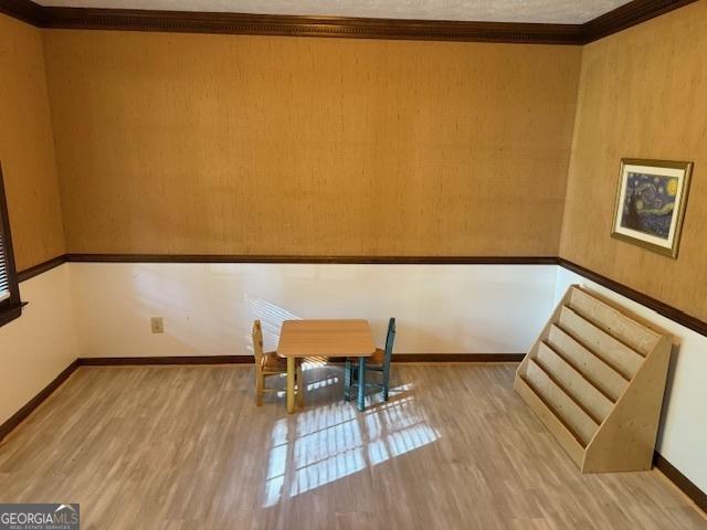 unfurnished dining area with ornamental molding, baseboards, and wood finished floors
