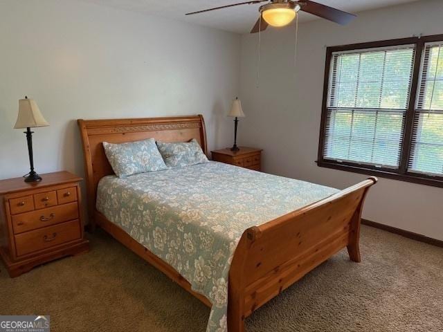 carpeted bedroom with ceiling fan and baseboards