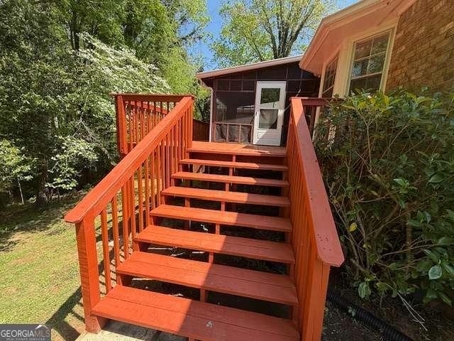 wooden terrace featuring stairs and a sunroom