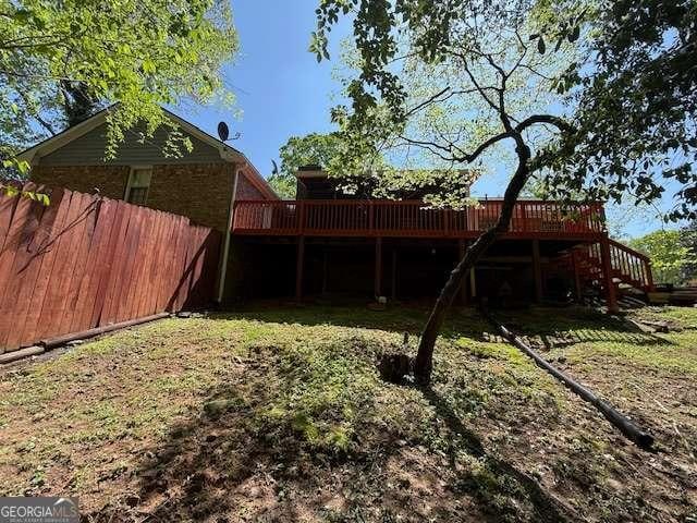 view of yard with stairs, a deck, and fence