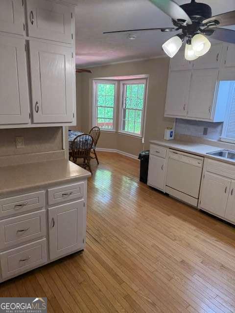 kitchen with light wood-style floors, ceiling fan, white cabinets, dishwasher, and light countertops