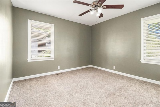 unfurnished room with a wealth of natural light, carpet, and baseboards