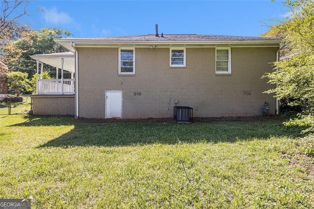 view of property exterior featuring brick siding, cooling unit, and a lawn