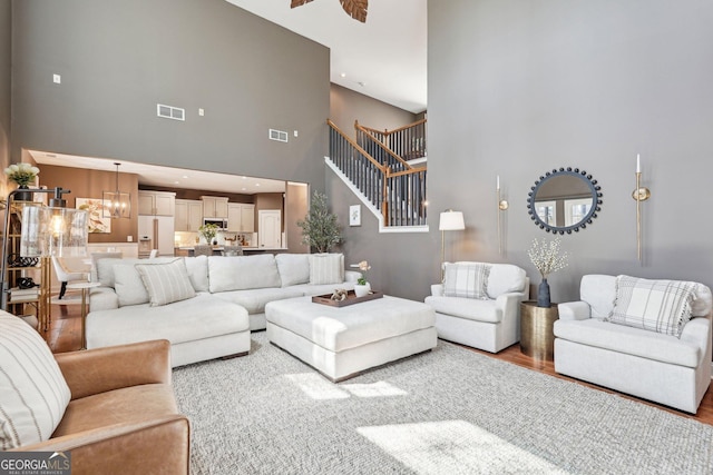 185 Starlight Dr, Dahlonega, GA 30533 - living room with a notable chandelier, visible vents, a high ceiling, and wood finished floors