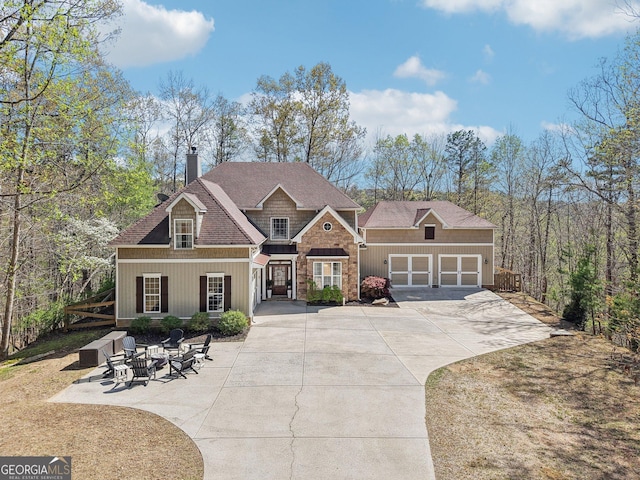 185 Starlight Dr, Dahlonega, GA 30533 - craftsman house with an outdoor fire pit, an attached garage, a chimney, concrete driveway, and roof with shingles