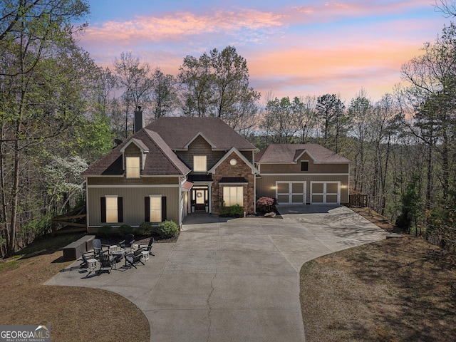 185 Starlight Dr, Dahlonega, GA 30533 - view of front of home featuring a shingled roof, an outdoor fire pit, stone siding, a chimney, and driveway