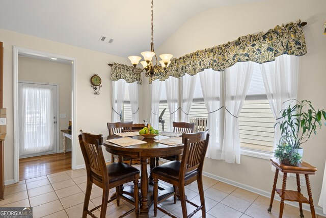 dining room featuring vaulted ceiling, visible vents, light tile patterned flooring, baseboards, and a notable chandelier