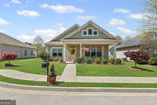 craftsman house featuring central AC unit, a front lawn, and covered porch