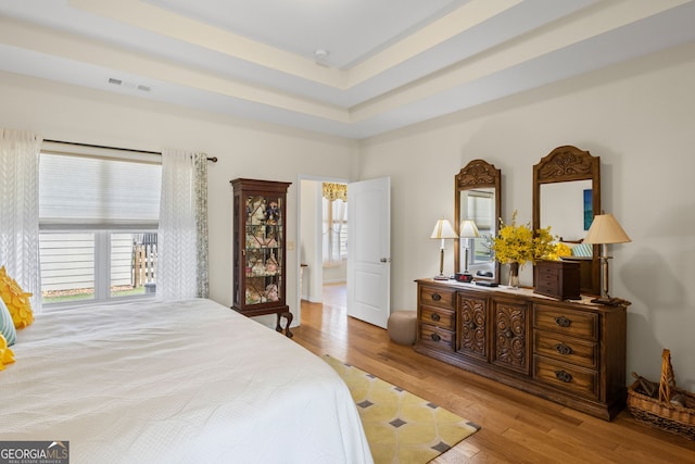 bedroom featuring wood finished floors, multiple windows, and visible vents