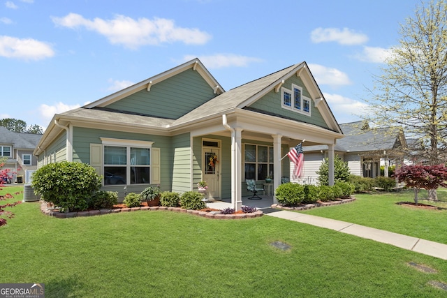 view of front facade featuring a front yard, central AC unit, and a porch