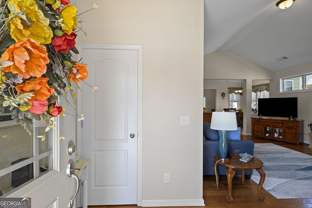 entryway featuring wood finished floors, baseboards, vaulted ceiling with beams, and visible vents