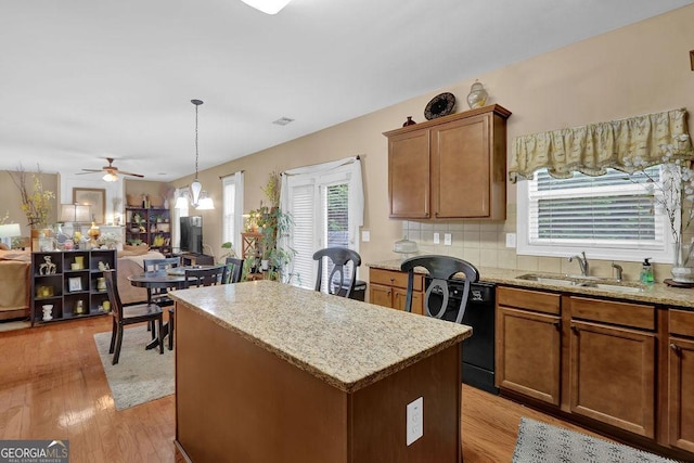 2384 Allsborough Way, Dacula, GA 30019 - kitchen with dishwasher, a sink, a kitchen island, light wood-type flooring, and brown cabinets