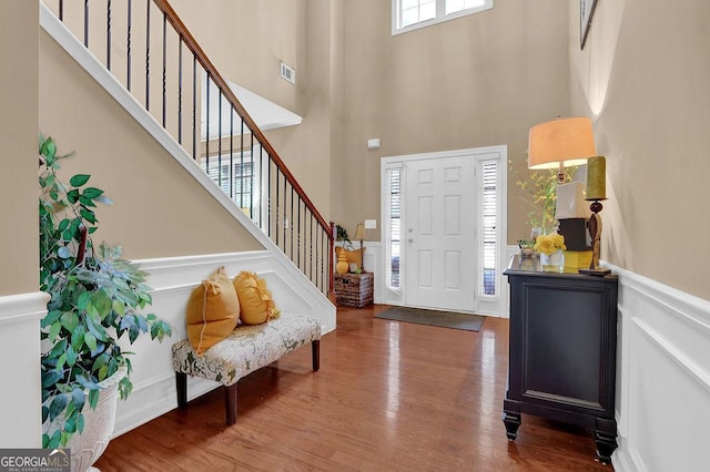 2384 Allsborough Way, Dacula, GA 30019 - entrance foyer with a towering ceiling, stairs, wood finished floors, wainscoting, and a decorative wall