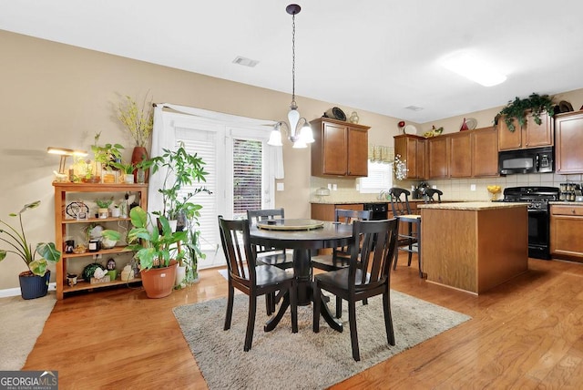 2384 Allsborough Way, Dacula, GA 30019 - dining area featuring a chandelier and light wood-style floors